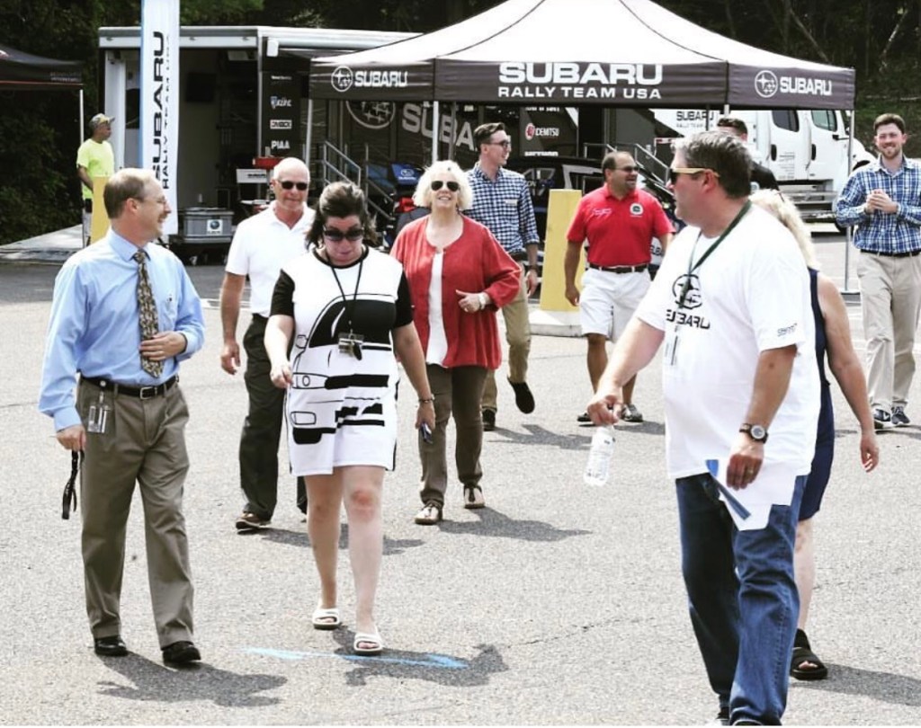 Group of people at a Subaru rally walking and laughing