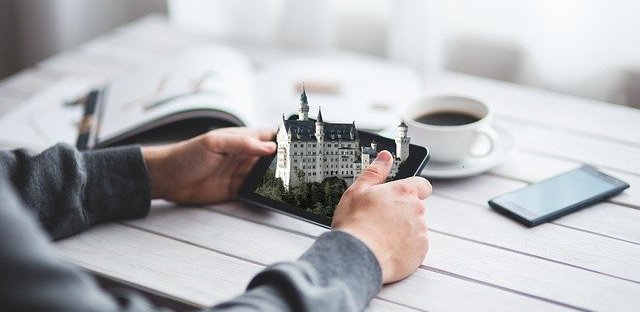 Close up of two hands holding a phone and a 3D castle is popping out of the phone screen